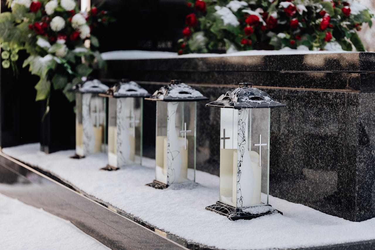 Inicio Cemetery lanterns in snow, creating a serene winter memorial scene.
